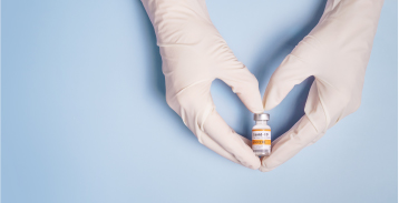 Hands with COVID vaccine bottle