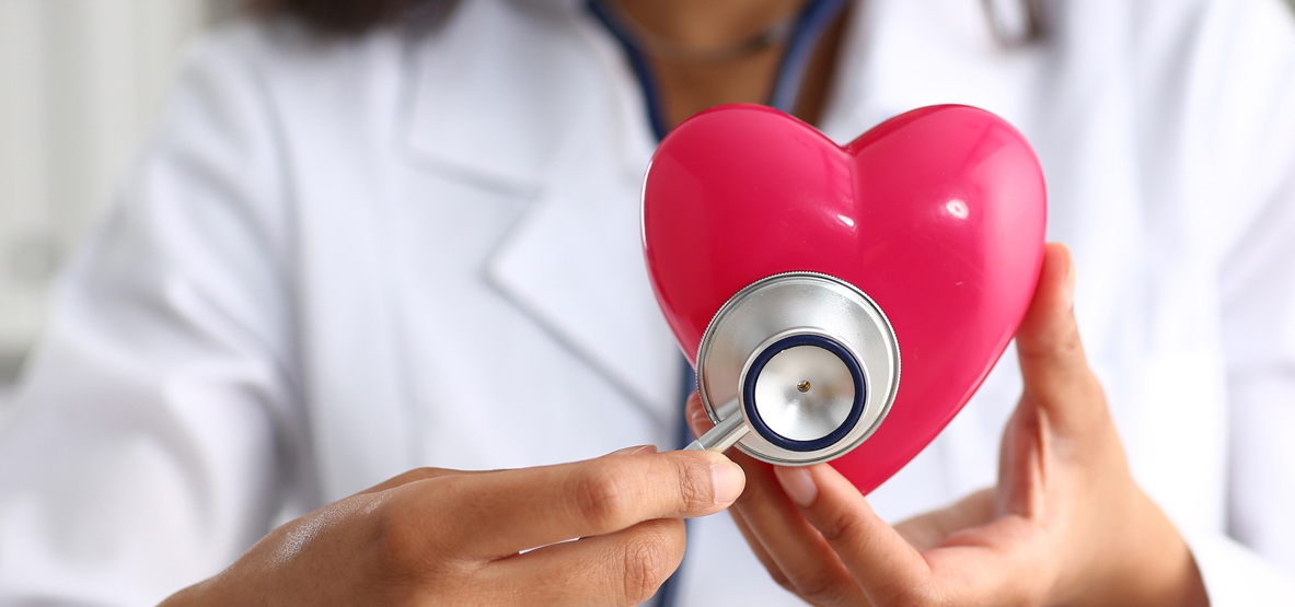 Doctor with stethoscope on a plastic heart