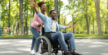 A women pushing a man in a wheelchair