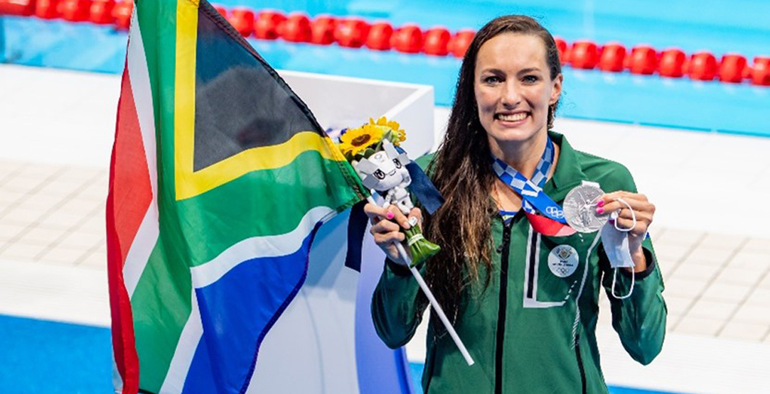 Tatjana Schoenmaker holding gold medal and South African flag