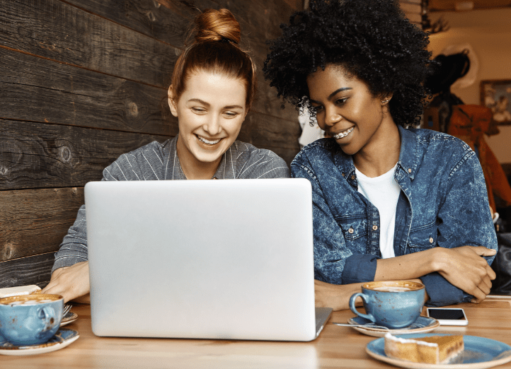 Friends smiling at laptop